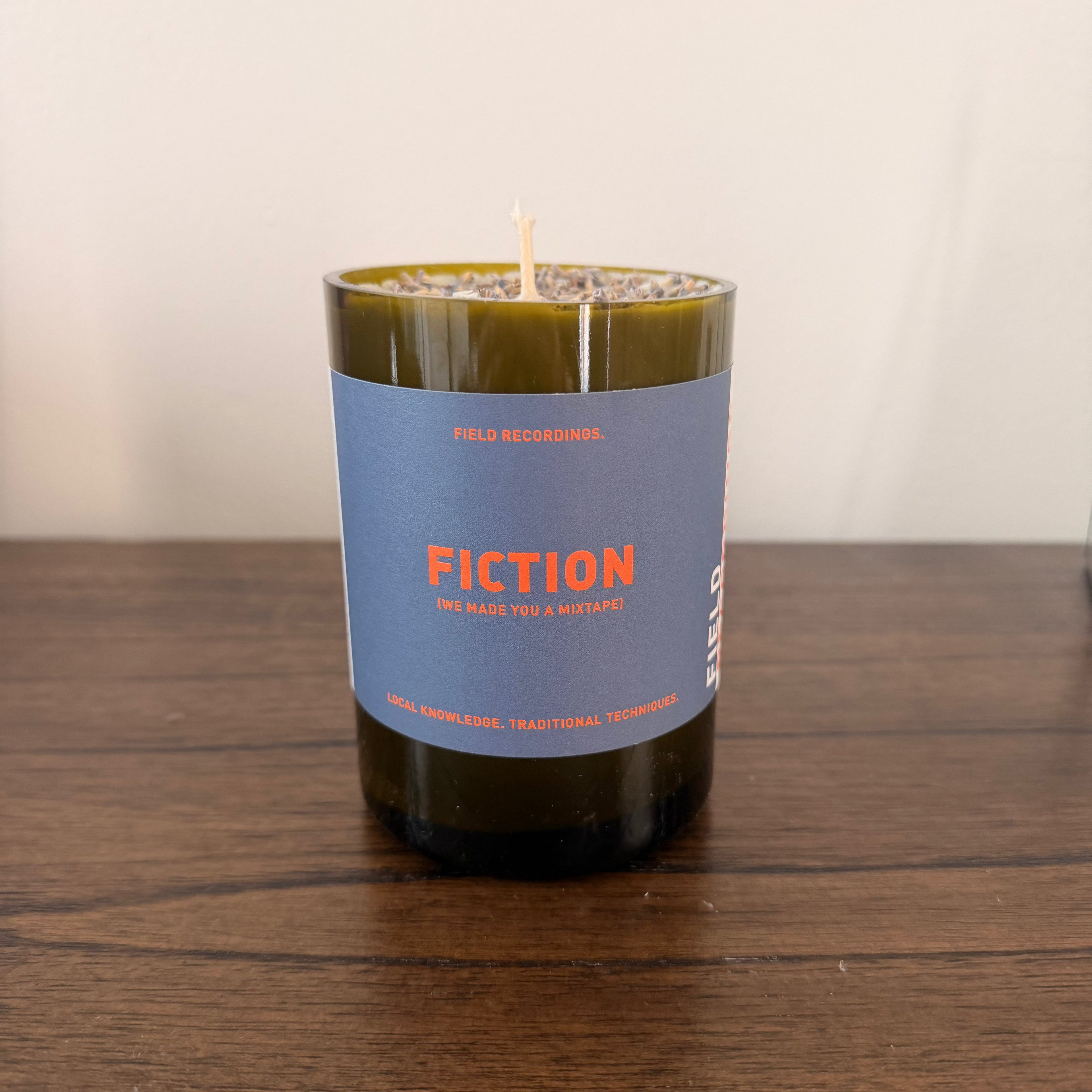 Candle with a blue label on a wooden surface